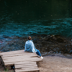 Girl Setting on a Blue Lake